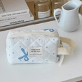 Primer plano del neceser acolchado blanco con estampado de lazo y lunares azules - Bolso de muñeca octogonal