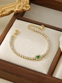 Macro shot of gold tennis bracelet with clear zircon stones and green center emerald cut gem - Green Rectangular Style (ZHB709 Green)