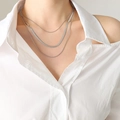 Collar plateado de tres capas con cadenas de serpiente planas en una modelo femenina - Collar de 3 capas / Color Acero
