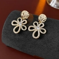 Gold flower earrings with white pearls and a central zircon on a grey jewelry stand - Gold-Pearl Petals (HE23405)