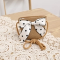 Detailed view of children's straw crossbody bag with white polka dot bow and hemp strap - Khaki Bag