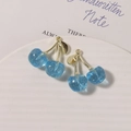 Detail van twee blauwe glitter kersenhangers met gouden metalen steeltjes en lusjes - Gouden Steel Glitter Blauw / 1 stuk