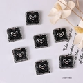 Macro view of vintage heart-shaped black and silver buttons sized 21mm by 20mm - Black Envelope