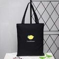 Black canvas tote bag with yellow lemon print and Freshlemon text on shoulder strap - Lemon Black