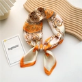Baroque style silk scarf in orange and cream draped on a wooden display board - Baroque Ornament Orange