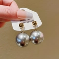 Élégantes boucles d'oreilles pendantes en perle gris argenté avec base dorée sur carte - Gris