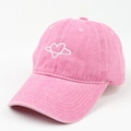 Close-up of pink washed canvas baseball cap with heart embroidery and vintage texture - Pink