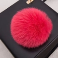 Vue détaillée d'un pompon en fourrure rose rouge duveteux sur un sac en cuir noir - Style Bouton Pression 14CM / Rose rouge