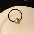 Minimalist elastic hair tie featuring a matte brushed golden metal sphere charm - Oval Ball / Gold