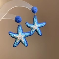 Détail de boucles d'oreilles étoile de mer en raphia bleu avec finition dégradée - Bleu