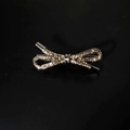 Detailed view of elegant silver bow hair clip with sparkling rhinestones on black background - Black