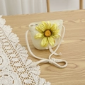 Dettaglio borsa a tracolla in paglia con decorazione a girasole su un tavolo di legno - 52cm 3-6 Anni / Borsa di paglia / Crema