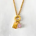 Gold stainless steel initial O necklace with pink crystal pendant on white background - Letter O