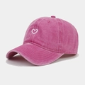 Close-up of rose pink washed cotton baseball cap with white heart embroidery detail - Rose Red