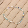 Handmade bead bracelet featuring white, gold, and blue glass beads on a beige display - Style 74-White Gold Blue Mix