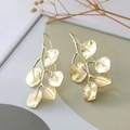 Detailed close-up of golden leaf-shaped metal earrings in a rustic setting - Gold Tree Branch Leaf Hooks (S3109)