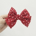Elegant red bow hair clip with white polka dots for women shown in hand display - Kids Duckbill Clip / Red Polka Dot