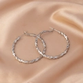 Silver geometric faceted hoop earrings displayed on premium champagne satin fabric - E-031---Platinum 40mm