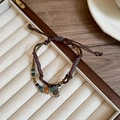 Detalle de una pulsera trenzada bohemia con cuentas de colores y colgante de sol retro - Pulsera - Marrón Doble Capa