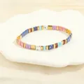 Close-up of colorful Tila beads and gold accents on a bohemian woven stretch bracelet - Royal Blue & Mauve Set