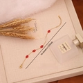 Gouden roestvrijstalen armband met vijf rode lippenhangers op een beige dienblad - 2# Rode Lip Armband