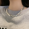 Detailed close-up of triple-layered silver flat snake chain and metal cross necklace on neck - L391 Three-Strand Criss-Cross Silver Necklace