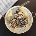 Three handmade beige felt donut keychains with black patterns on a French script plate - Croissant