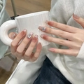 Detail of square nude gradient press-on nails with rhinestone accents on a white mug - By1492 Nightingale's Song / Phototherapy Glue Style