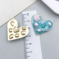 Detail of heart pendants with blue enamel, pearls and gold texture next to a ruler - Lake Blue Heart Pearl Butterfly Rose-23597