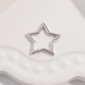Macro shot of silver hollow star-shaped clasp jewelry accessory on ceramic surface - Type B: White Gold Star