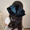 Detail of large black mesh bow hair clip on long wavy hair from back view - Black