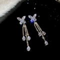 Vue détaillée des boucles d'oreilles papillon en argent avec cristaux sur fond noir - No.47 Argent Papillon Pompon Boucles d'Oreilles