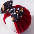 Detail van de rode gebreide babymuts met een grote strik en botpatroon op de strik - Rood