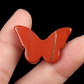 Polished red jasper butterfly stone ornament with natural stone veins on dark background - Red Jasper