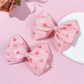 Primer plano de pinzas para el cabello de satén rosa con patrones de corazones - Pinzas para el Cabello con Lazo (1 Par)