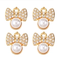 Detail of four golden bow pendants with inset pearls and sparkling cubic zirconia stones - Bowknot Rhinestone Pearl (px1086-14)
