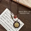 Collier bohème en perles de bois avec pendentif spirale en métal et nœud doré - Style Motif Spiralé Doré