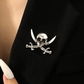 Dettaglio della spilla a teschio pirata vintage in argento sul risvolto di un blazer - Stile Teschio Pirata Doppia Spada Argento Antico (S569)