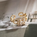 Macro shot of gold vintage ring with square clear zircon and chain band on a book - Gold
