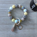 Detail view of silicone bead keychain with pumpkin-shaped beads and a leather tassel - Gray