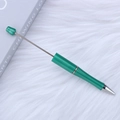 DIY green beaded ballpoint pen with a customizable metal rod on a plush white background - Glass Green