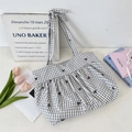 Detail of checkered canvas tote bag featuring black bow embroidery and ribbon straps - Black Grid Black Bow