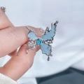 Détail d'une bague papillon irrégulière avec pierre bleue et finition argent liquide - Style 2 Bague Ouverte Papillon