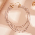 Detalle de collar de perlas de cuatro capas con cadena dorada y adornos de strass - Perla Blanca