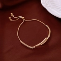 Vue macro d'un bracelet doré avec détail de clou en zircone et fermoir coulissant ajustable - Bracelet Coulissant Inspiré du Clou Or