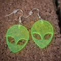 Neon green fluorescent acrylic alien head earrings with glitter on a textured surface - Fluorescent Green