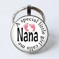 Silver round keychain with Nana text and pink baby footprints for a special little girl - Nana/Pink Footprints