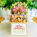 Detailed view of a 3D pop-up Christmas card box featuring a cozy snowman and fireplace scene - Yellow Christmas