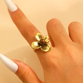 Close-up of golden four-petal flower ring with brown gemstone on model's finger - Gold (Z-299)