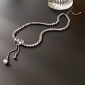 Detalle del collar con lazo plateado con circonitas y elegantes borlas de perlas - Estilo Borla Lazo Plateado
